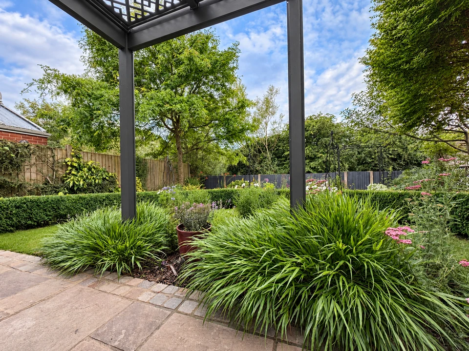 Grey pergola framing a garden with lush planting and a paved patio